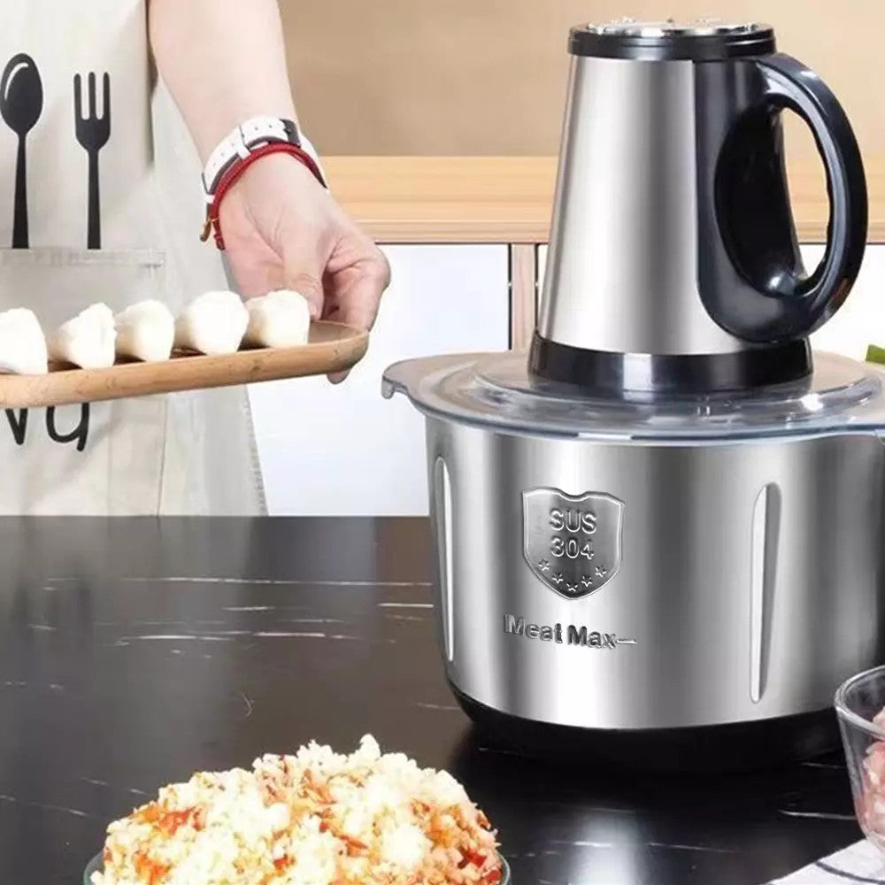 Stainless steel food processor on a kitchen counter with popcorn and a hand holding food items.